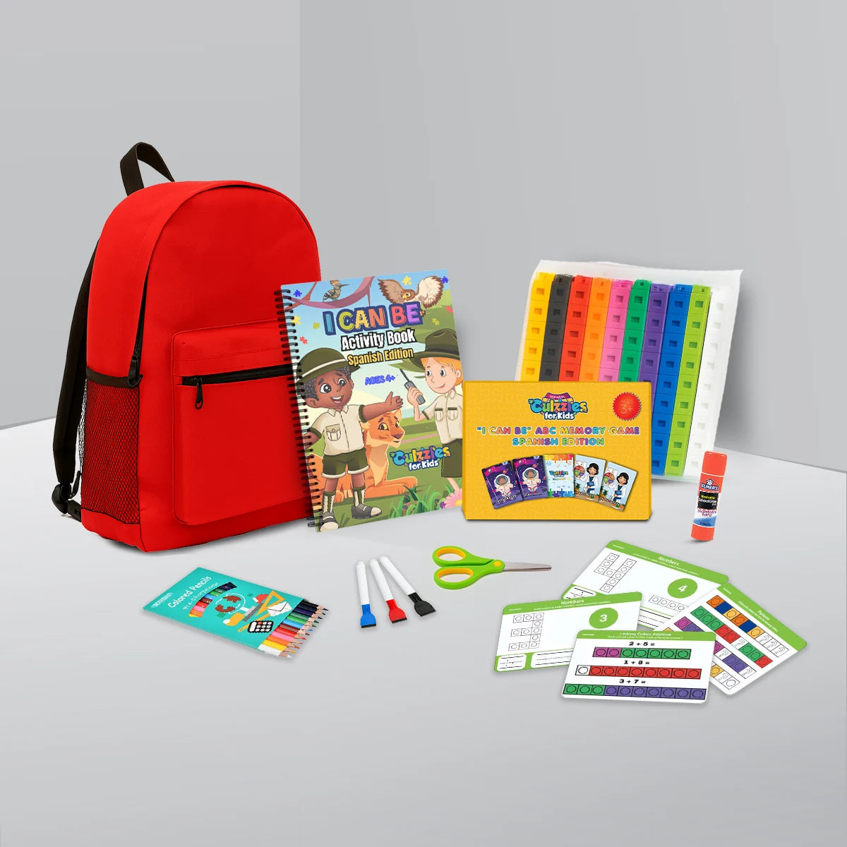 Culzzles Spanish kindergarten readiness educational materials for kids, including a red backpack, learning games, literacy-building materials, activity books, and stationery on a gray surface.